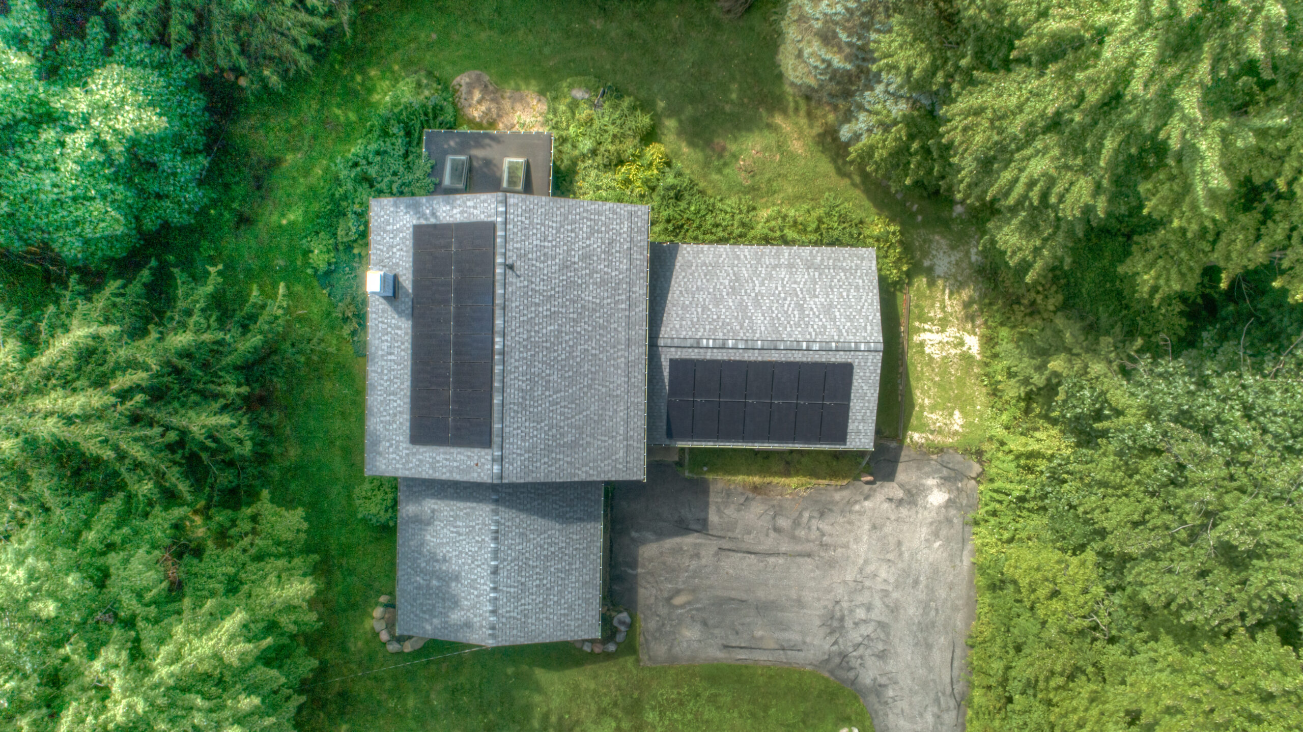 Arial view of a solar system on a home surrounded by trees. What's the difference between a kilowatt and a kilowatt hour?